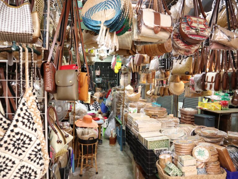Woven bags, hats, and baskets hanging densely at a Chatuchak craft stall