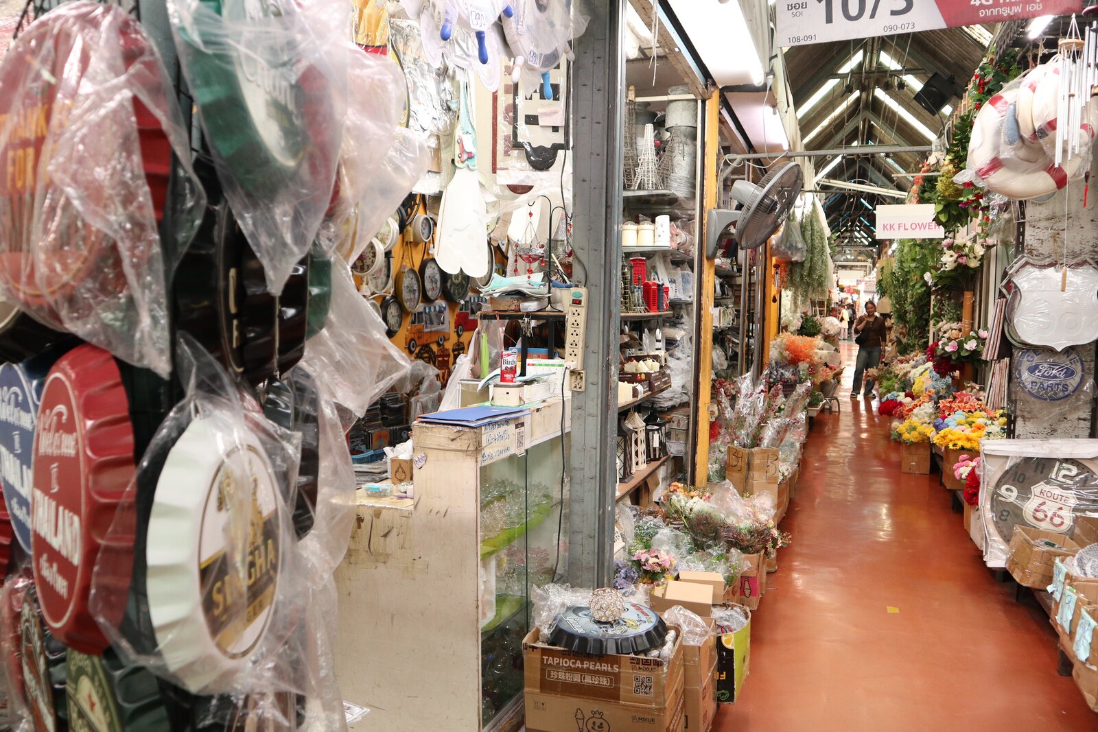 装飾看板や花を並べた売場の間を奥へ続くチャトチャックの路地