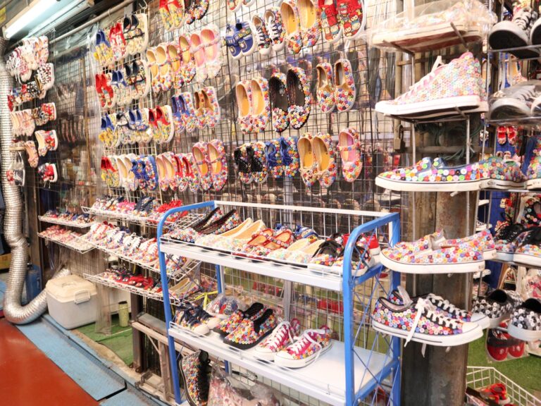 Colorful button-decorated shoes displayed at a Chatuchak Weekend Market stall
