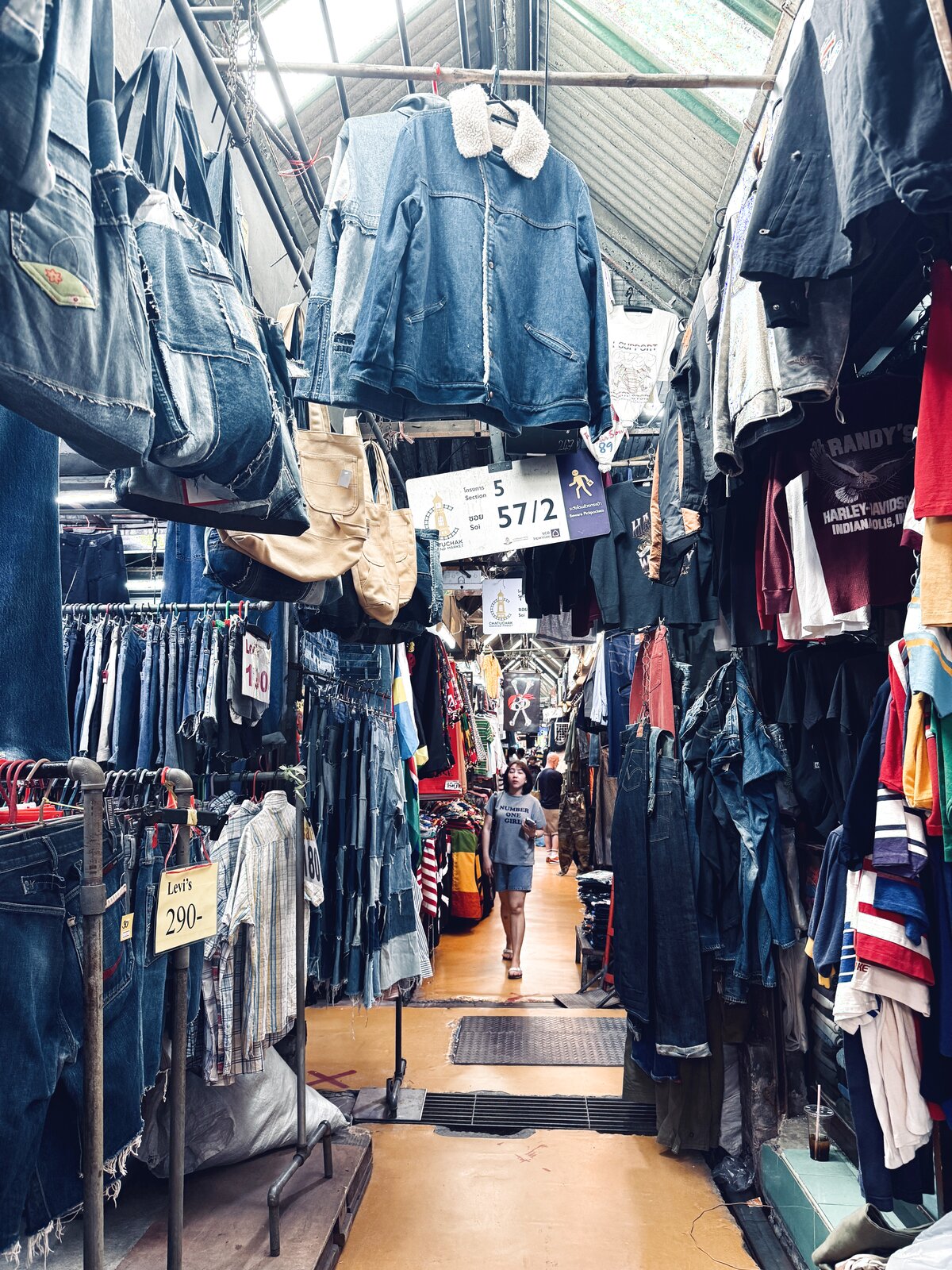 デニム古着が並ぶ通路と「Section 5, Soi 57/2」の看板