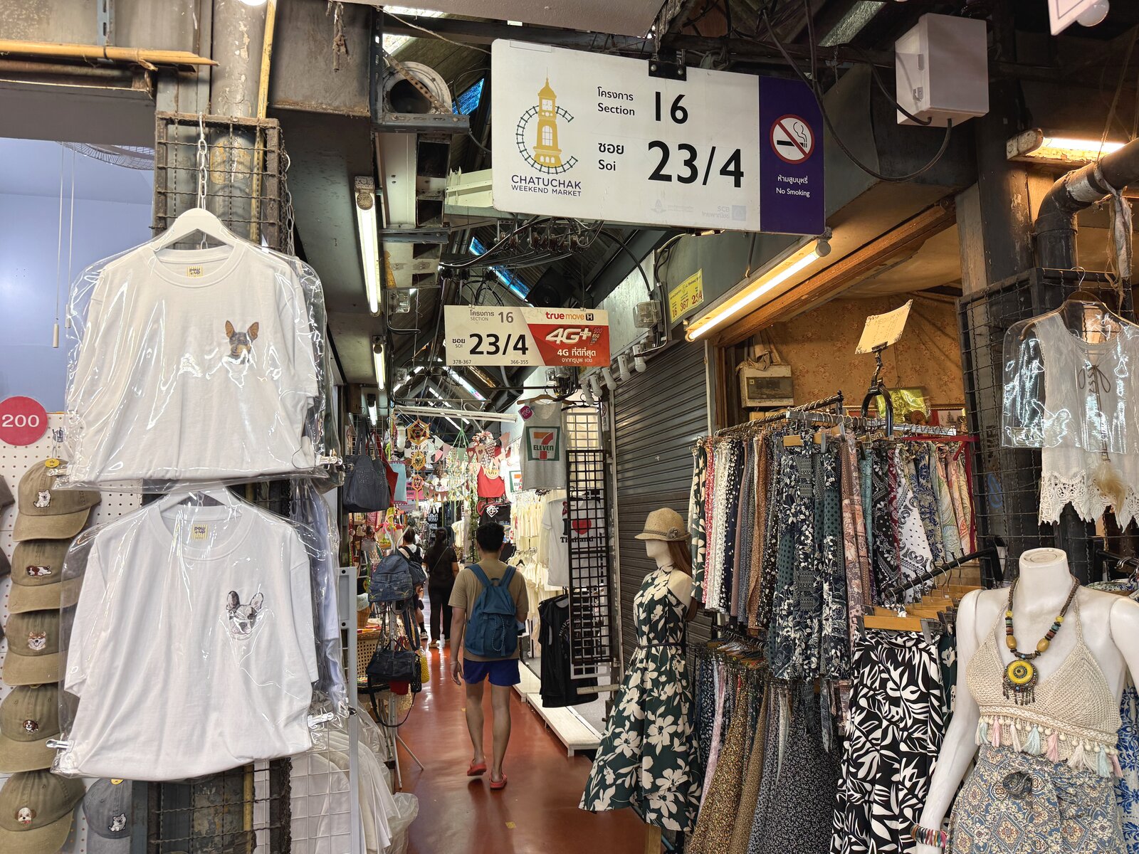 「Section 16, Soi 23/4」の案内表示と、衣料品が並ぶ通路