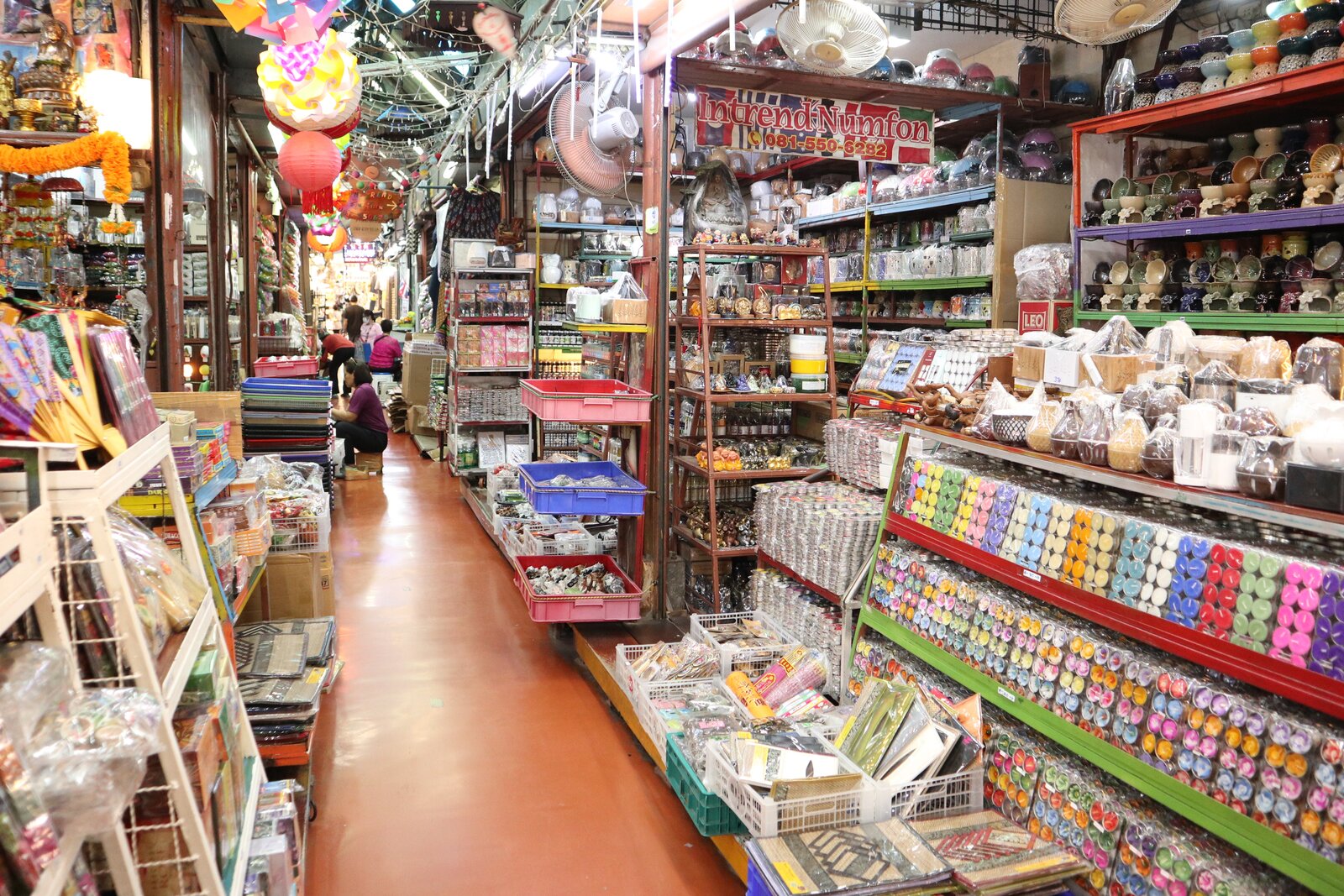 商品が並ぶ細い店内通路と、その奥にいる人物