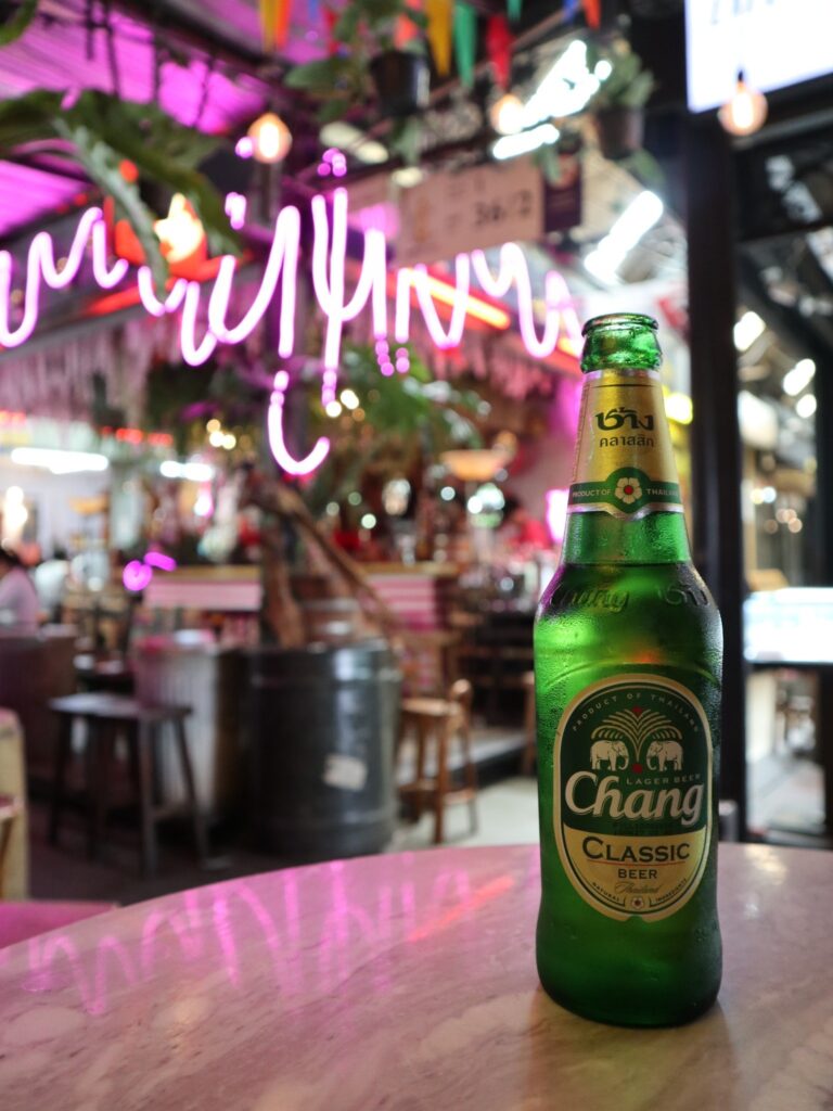 A bottle of Chang beer against the neon-lit interior of The Secret