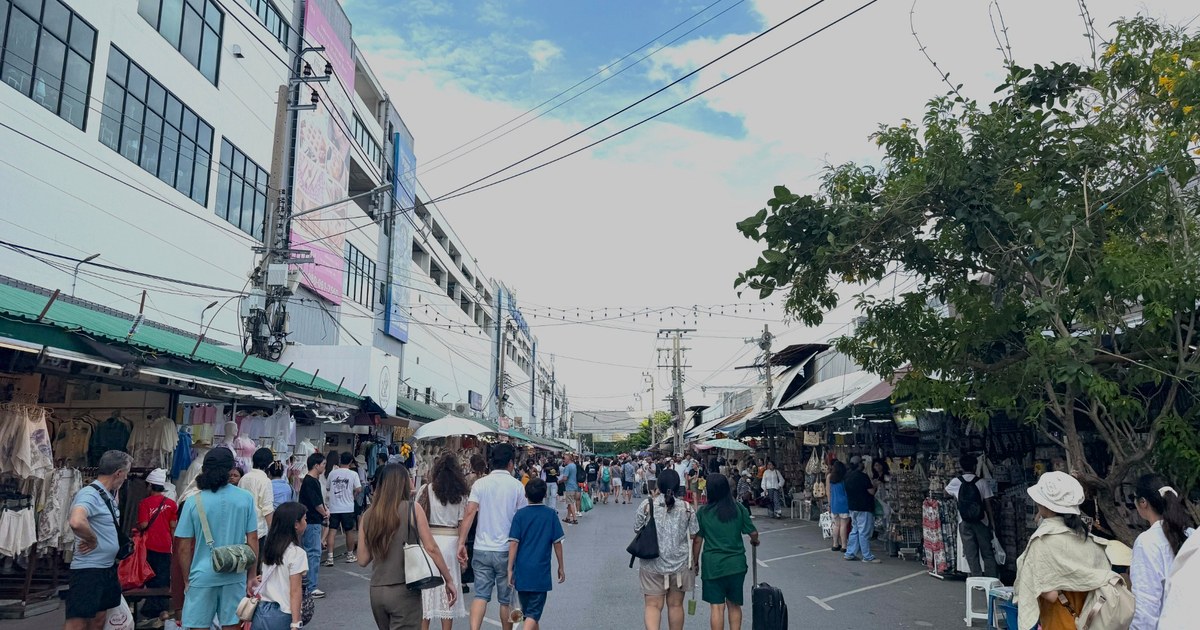 Visitors walking along a wide outdoor lane at Chatuchak Weekend Market
