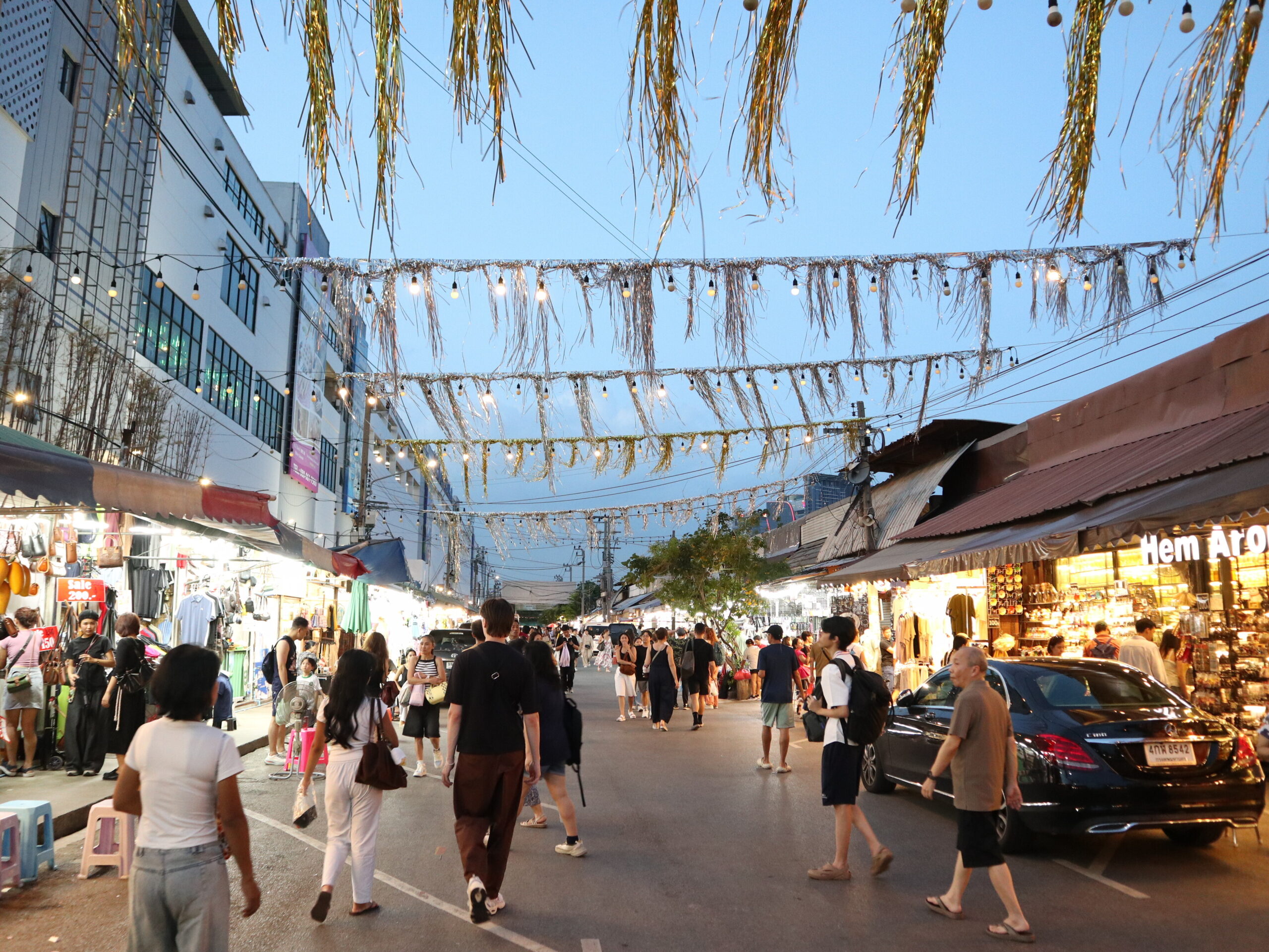 Visitors walking through a Chatuchak street at dusk