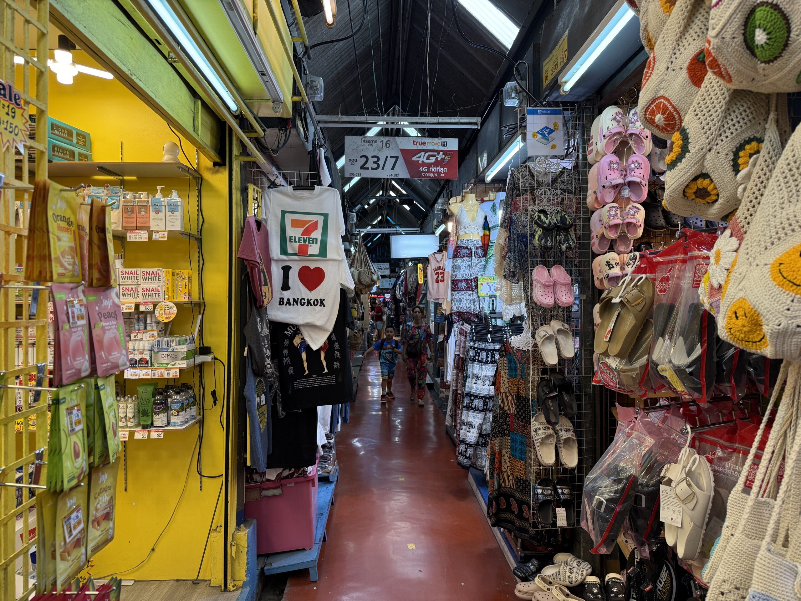 A narrow aisle extending beyond the Section 16 and Soi 23/7 sign