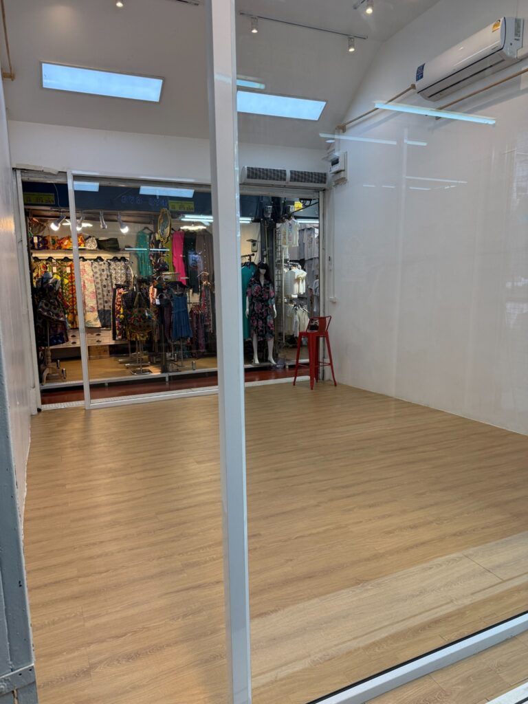 Empty Soi YIPUN interior viewed through the glass storefront