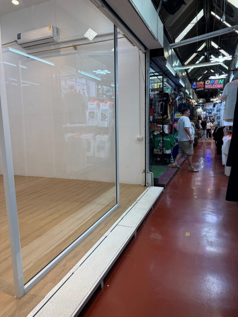 Glass-fronted Soi YIPUN shop facing a Chatuchak market lane