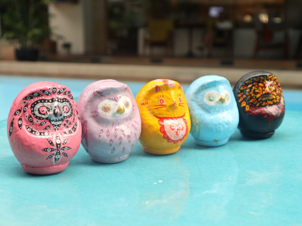 Five colorful hand-painted Daruma art pieces