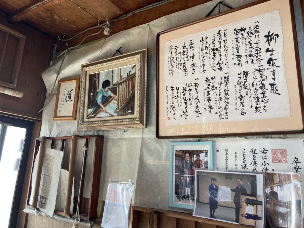 Documents and photographs displayed inside the Yanagiu washi workshop.