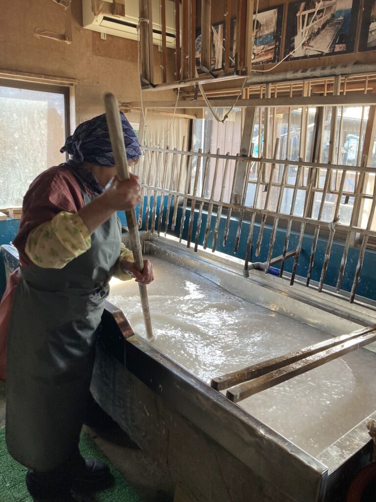 A person working with a papermaking screen at the workshop.