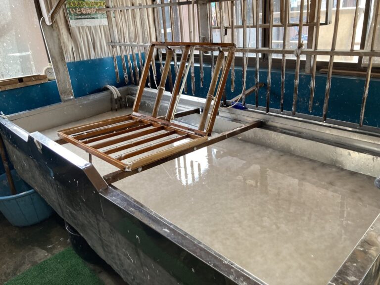 Papermaking equipment and wooden frames inside the workshop.